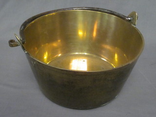 A polished brass preserving pan with iron handle