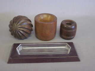 A turned Eastern wooden ball, a turned Lignum Vitae stable  block, turned wooden vase and a rectangular desk tidy by Harrods