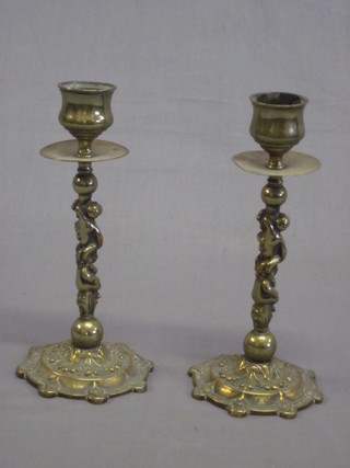 A pair of brass candlesticks the stems decorated cherubs 6"