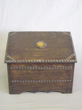 A 1930's oak box with hinged lid, the interior fitted 2 square cut inkwells, the base fitted a drawer 9"