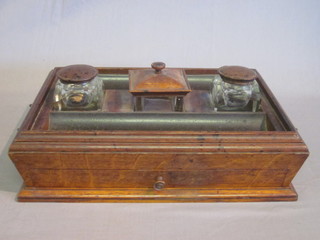 A 19th Century rectangular oak standish with bronze drop handles to the sides, the centre fitted a seal box and 2 cut glass  inkwells with pen recess, the base fitted a drawer 15"