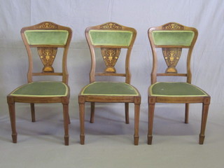 A set of 3 Edwardian inlaid mahogany dining chairs with shaped backs and upholstered seats, raised on square tapering supports