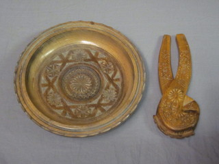 A circular carved wooden bowl 8 1/2" and a pair of carved  wooden nut crackers