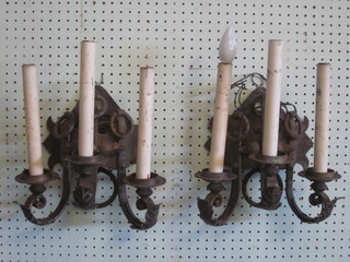 A pair of wrought iron 3 light wall brackets