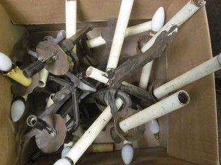 A box containing various wrought iron wall light brackets