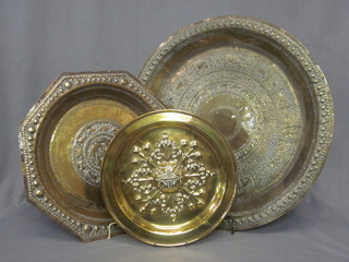 A circular embossed brass charger 14", a Benares embossed brass charger 24" and an octagonal charger 18"