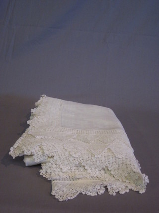 A white linen table cloth with embroidered border