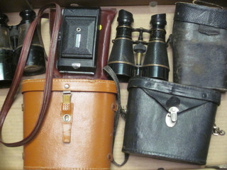 3 pairs of binoculars, 2 leather binocular cases and a folding  camera