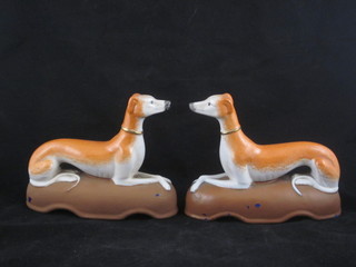 A pair of Staffordshire figures of reclining greyhounds, bases painted 7"