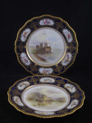 A pair of Royal Worcester porcelain plates with blue and gilt  banding and floral decoration, the centre panels painted Blackness  Castle and Hilchin Castle, having panels painted by Stinson, the  reverse with purple Worcester mark, 1 star, 2 dots and incised  N5, 9"  ILLUSTRATED