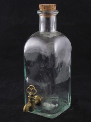 A square clear glass bottle with brass spicket 7"