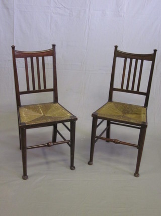 A pair of Edwardian Art Nouveau mahogany stick and rail back  bedroom chairs with woven rush seats