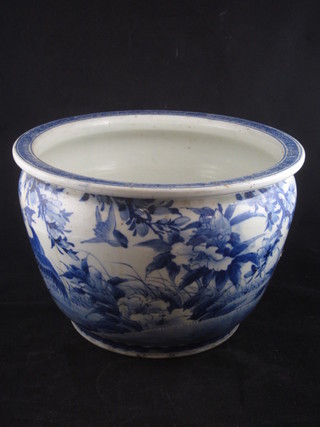 An Oriental blue glazed porcelain fish bowl decorated birds  amidst branches, drilled to base and with crack