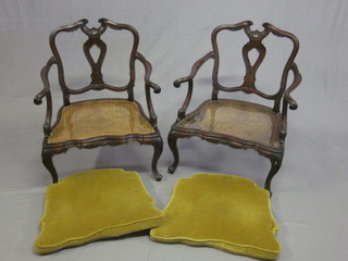 A pair of 19th Century Continental carved walnut open arm  chairs with woven cane seats, raised on cabriole supports
