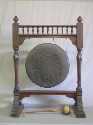 An Edwardian bronze dinner gong raised on a turned walnut  stand with bobbin turned decoration 27"