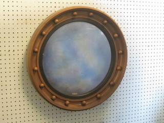 A circular convex plate wall mirror contained in a ball studded  frame 19"