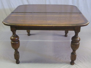 An Edwardian oak oval extending dining table, raised on turned  and block supports 52"