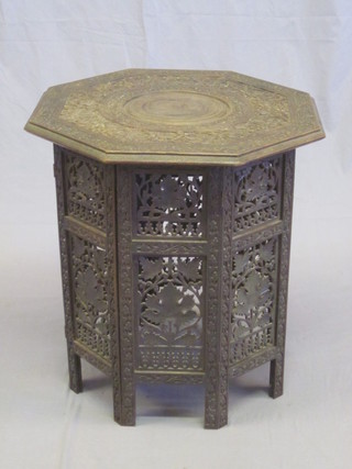 An octagonal carved Moorish coffee table, raised on a folding stand 20"
