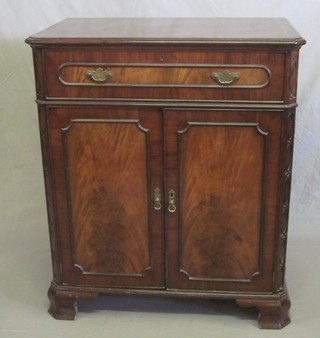 A Georgian style television cabinet with crossbanded top fitted a drawer above a double cupboard, raised on ogee bracket feet 33"