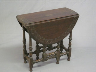 A Victorian carved oak oval drop flap tea table, raised on turned supports 27"