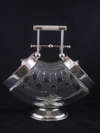 An Edwardian cut glass crescent shaped biscuit barrel with silver plated mounts 9"
