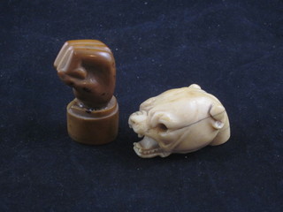 A carved ivory walking stick head in the form of a growling dog  2" and a seal in the form of a clenched hand 2"