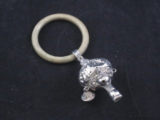 An embossed silver rattle, marks rubbed