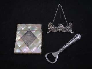 A mother of pearl card case inlaid silver decoration, f, a crown cork bottle opener and a pierced white metal menu holder