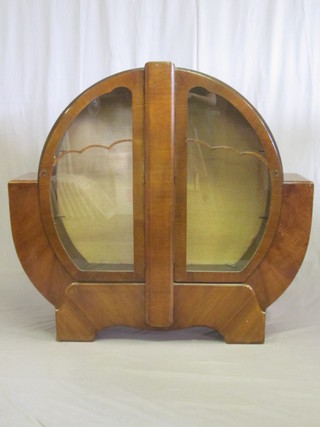 An Art Deco walnut circular shaped display cabinet, the interior fitted shelves enclosed by glazed panelled doors 52"