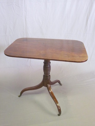 A 19th Century rectangular mahogany snap top wine table, raised  on a turned column and tripod base ending in brass caps and  castors 32 1/2"