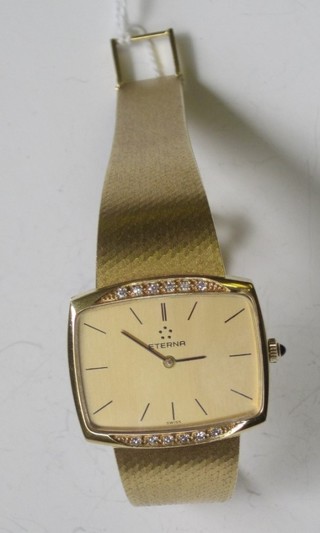 A lady's Eterna wristwatch contained in an 18ct gold case, set diamonds to the bezel and with integral gold bracelet, boxed and  with original documents
