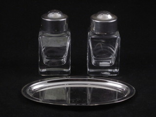 A 2 piece glass and Maltese silver condiment set with salt and pepper pot raised on an oval tray