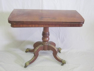 A Victorian mahogany D shaped folding card table, raised on a baluster turned column with tripod base ending in brass caps and  castors 37", top warped,