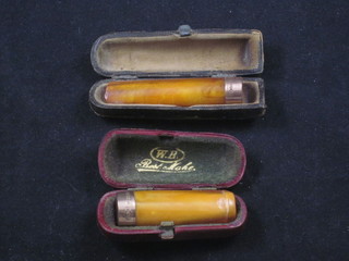2 amber and 9ct gold mounted cigar holders