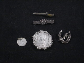 A Victorian silver brooch formed from a half crown, 2 silver brooches, a brooch in the form of a bayonet and a silver pendant