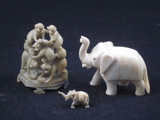 A carved ivory figure of an elephant 3", 1 other 1" and a  soapstone figure group of monkeys 3"