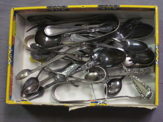 A collection of silver plated sugar tongs and other plated  flatware