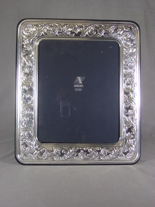 A modern silver easel photograph frame with embossed  decoration 13" x 11"