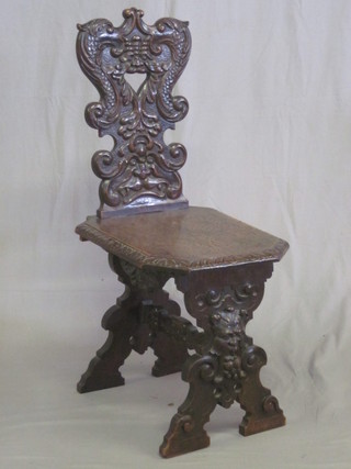 A Continental carved mahogany hall chair with solid seat, raised  on X framed supports