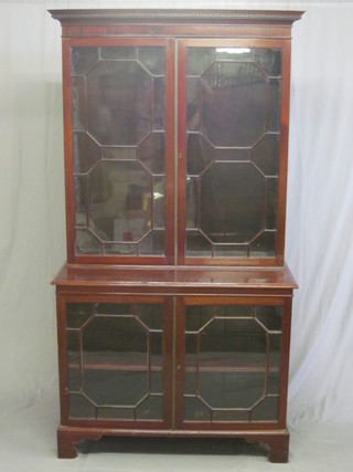 A 19th Century mahogany display cabinet on cabinet with  moulded and dentil cornice, both sections fitted adjustable shelves  enclosed by astragal glazed panelled doors, raised on bracket feet  42"