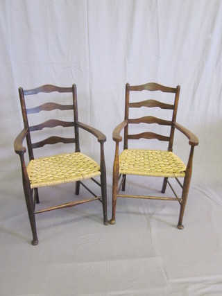 A pair of oak Art Nouveau style ladder back carver chairs with woven rush seats