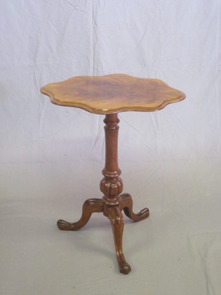 A shaped bleached walnut wine table, raised on a turned column  and tripod base 23"