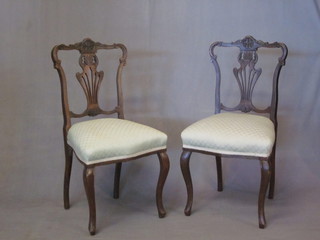 A pair of Edwardian mahogany chairs with pierced vase shaped slat backs, the seats of serpentine outline and raised on French  cabriole supports