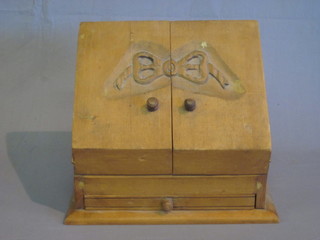 A pine stationery box enclosed by a pair of panelled doors, the base fitted a drawer 12"