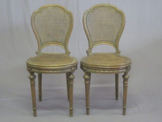 A pair of French 19th Century salon chairs with woven cane seats and backs, raised on turned and fluted supports