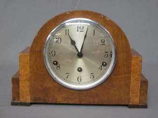 A 1930's walnut chiming mantel clock with silvered dial  contained in an arch shaped case