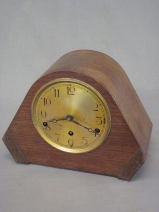 A 1930's chiming mantel clock with silvered dial and Arabic  numerals contained in an oak arch shaped case