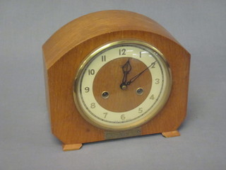 A 1950's 8 day striking mantel clock with Arabic numerals  contained in a light oak arch shaped case