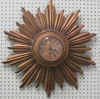 A 1930's 8 day wall clock with silvered dial and Arabic numerals contained in a carved giltwood sunburst case