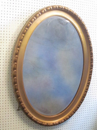 An oval bevelled plate wall mirror contained in a gilt frame 35"